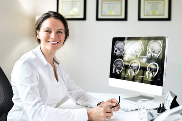 Neurosurgeon Neurosurgeon smiling at her desk.